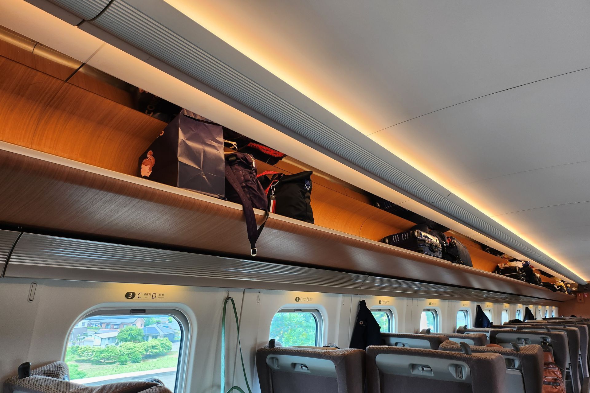 Breda bagagehyllor ovanför sätena på Shinkansen